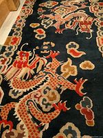 Close-up showing detailed dragon design, red and beige colors, and high knot density.