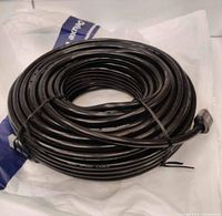 Coiled black HDMI cable showing full length and thickness placed on a white surface.