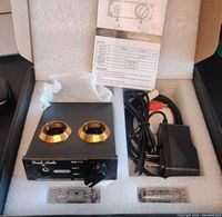 Overall lot layout inside packaging foam including preamplifier, two vacuum tubes, power adapter, RCA cable, and manual.