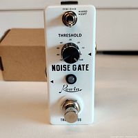 Front view of white Rowin LEF-319 Noise Gate pedal showing threshold knob, mode toggle switch, footswitch, LED indicator, and branding