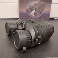 Side view of Occer 12x25 compact binoculars showing eyepiece caps and focus wheel.
