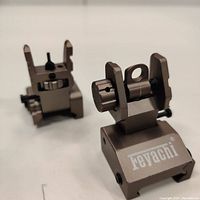 Close-up of two steel iron sights from a slightly above angle, showing adjustment knobs and brand name 'Feyachi'.
