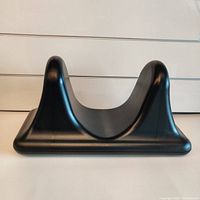 Front view of black plastic Psoas muscle release tool showing contoured cradle and raised supports for muscle pressure application.