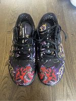 Top view of pair of Nike men's cross training shoes in ninja color showing detailed graphic design with red wolf prints on the toe area.