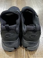 Top rear view of the black Nike shoes showing heel branding and pull tabs