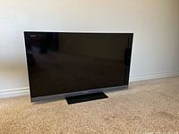 Front view of Sony Bravia 50-inch LED TV showing the screen and stand on carpeted floor.