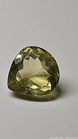 Faceted pear cut lemon citrine gemstone from front angle showing clarity and facets.