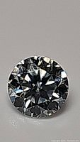 Close-up photo of the 5mm round brilliant cut moissanite gemstone showing its facets and sparkle.