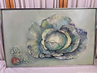 Front view of the vintage produce painting showing the large cabbage as main subject with tomato and grapes on left side, framed but no glass visible.