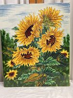 Front view of the decorative ceramic tile with raised edge sunflower design.