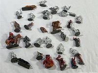 View of the full lot showing around 30 Ral Partha metal miniatures in various states of paint and poses on bases.