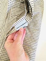 Close-up photo showing the Marimekko brand label sewn on beige fabric with black dots.