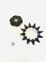 Pair of black mid-century candle holders from Jens Quistgaard Dansk showing two distinct sculptural designs on white background