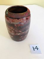 Front angled view of the raku vase showing red and black textured glaze on cylindrical form