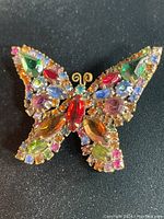 Front view of vintage butterfly brooch with colorful rhinestones detailing.