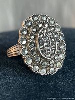 Close-up of oval vintage sterling silver ring with marcasite stones and ridged band, showing the front face of the ring.
