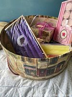 Box with various candles including taper candles, tea lights, and decorative candles.