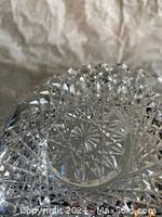 Close-up photo of the bottom of the smaller clear crystal dish showing star pattern and intricate cut design.
