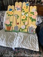 Full front view of the painted wooden fireplace screen with garden-themed decoration including sunflowers, roses, shovel, watering can, and birds