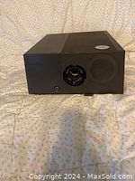 Front view of one Sawyer's 550 slide projector showing lens, adjustment ring and knob on black casing