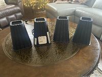 Four black bed risers on a table, two with power outlet panels visible.