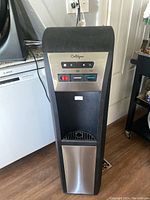 Front view of Culligan water station showing control panel with hot, room temperature, and cold water buttons, power icon, and stainless steel bottom panel covering water jug compartment.