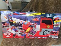 Box showing full folded and unfolded playset with vehicles and features highlighted.