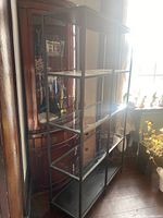 Full view of the IKEA Vittsjo shelf showing metal frame and four shelves, three of which are glass and one solid bottom shelf