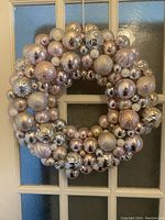 Full front view of the wreath hanging on a glass-paneled door, showing the overall size and color scheme.