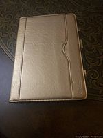 Closed view of the gold Pro-Case tablet cover showing smooth synthetic leather with stitched edges and Pro-Case logo.