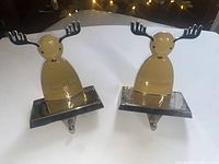 Two heavy metal Rudolph reindeer stocking holders with black antlers and red noses, shown side by side on a white backdrop.