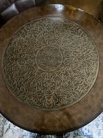 Top view showing the embossed floral pattern on the coffee table top with central medallion and surrounding scrollwork.
