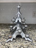 Front and top angle view of vintage silver metal Christmas tree-shaped candle holder with 12 tea light holders and star topper.