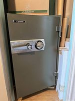 Closed view of Chubb safe with combination dial and handle on door, safe slightly open