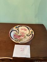 Top view of the porcelain decorative bowl showing floral design, curved edges, and cut-out details.