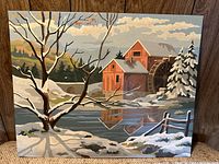 Full view of the oil on board painting showing the snowy landscape, watermill, tree, and reflective pond.