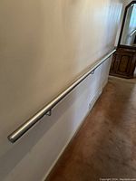 Side view of the entire metal rail mounted on the wall, showing length and positioning in room.