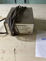 Front view of the Archer brand metal-encased volt power converter with electrical cord and visible branding and label.