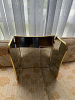 Front view of the three-way mirror showing the gold frame and the three glass panels, including the central larger mirror and two smaller side mirrors.