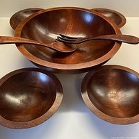 Front view showing large salad bowl centered with four smaller bowls arranged around, salad fork and spoon inside the large bowl