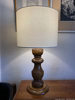 Full view of the vintage hand turned wood lamp with fabric shade, showing overall design and condition.