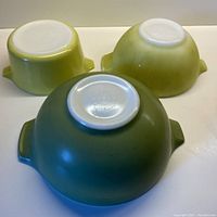 Photo of the bottoms of the three PYREX handled bowls arranged upside down showing color and markings.