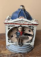 Front view showing figure, tray and dome top