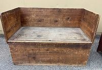 Front view of the antique wooden bench showing seat, backrest, and sides.