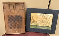 Photo showing both the framed folk art painting and the wooden checker board side by side.