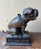 Side view of bulldog bank showing 'BULL DOG BANK' inscription on base and overall paint wear
