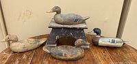 Four vintage wooden duck decoys on display showing overall lot contents.