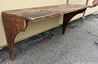 Side angled view of the wooden hanging shelf showing top surface and bracket support with carved details.