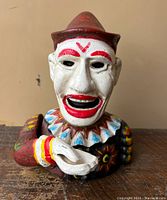 Front view of the clown bank showing detailed face, red hat, and painted features with extended hand bowl.