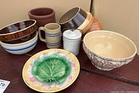 Photo showing entire collection including bowls, mug, covered jar, pot, and Majolica plate